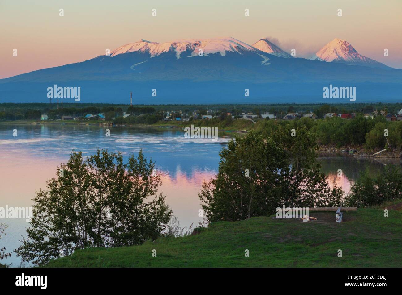 Sonnenuntergang Kluchevskaya Lichtkonzern der Vulkane mit Spiegelbild im Fluss Kamtschatka. Stockfoto