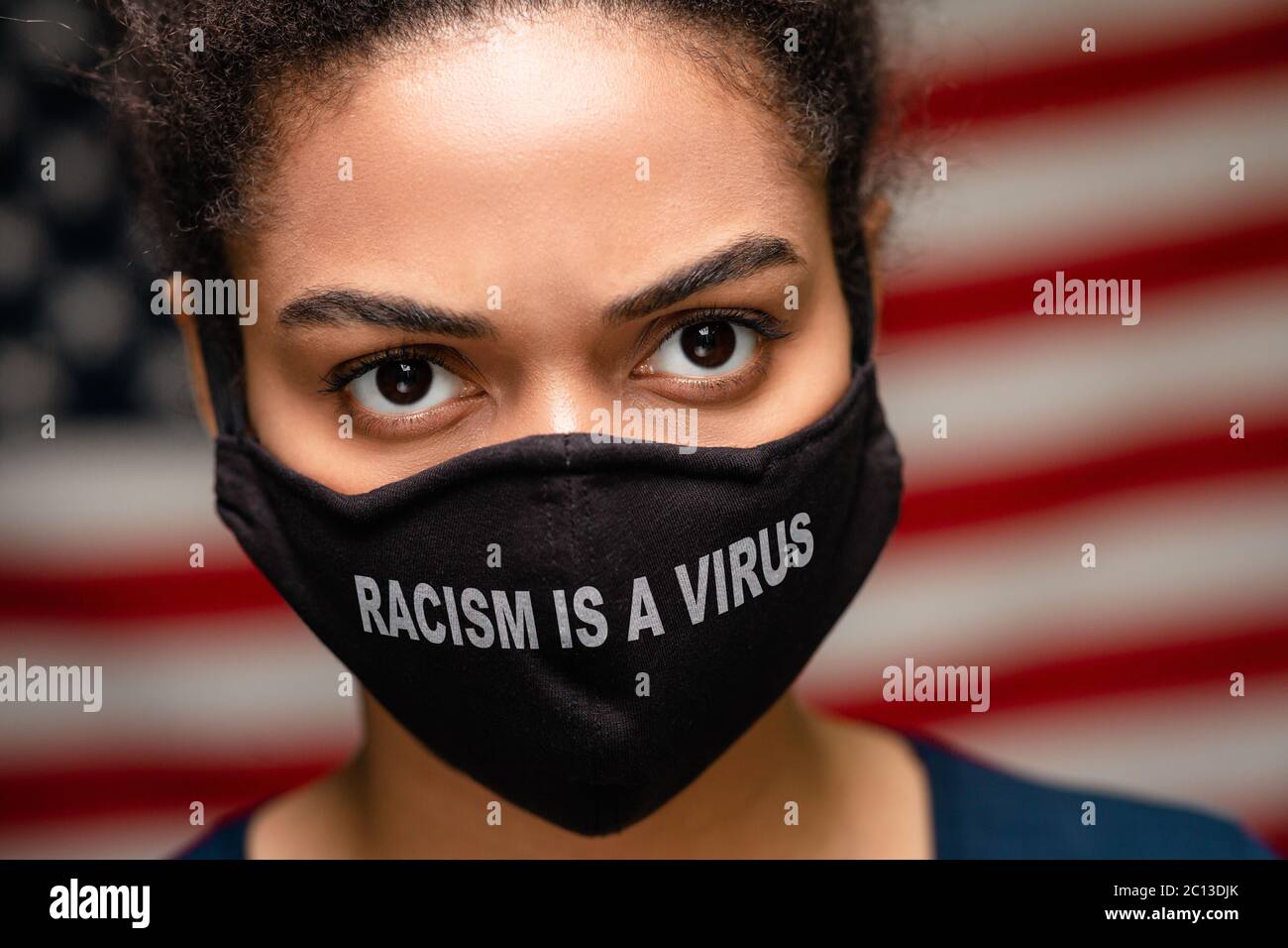 Porträt der schwarzen Frau trägt Schutzmaske mit Text Rassismus ist ein Virus Stockfoto