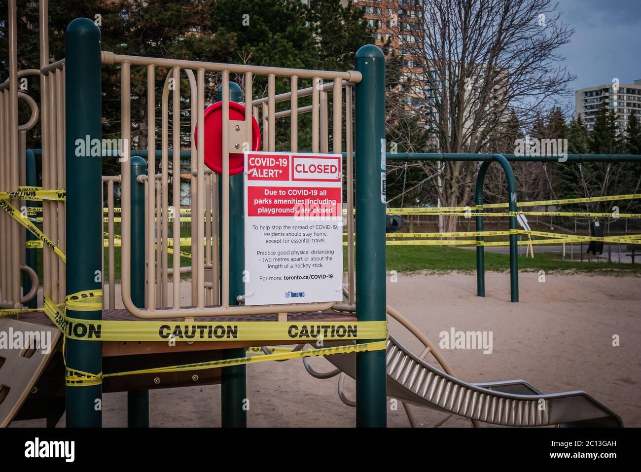 Ein covid-19 geschlossenes Schild mit Vorsichts-Klebeband auf einem Spielplatz im Freien in Toronto Kanada Stockfoto