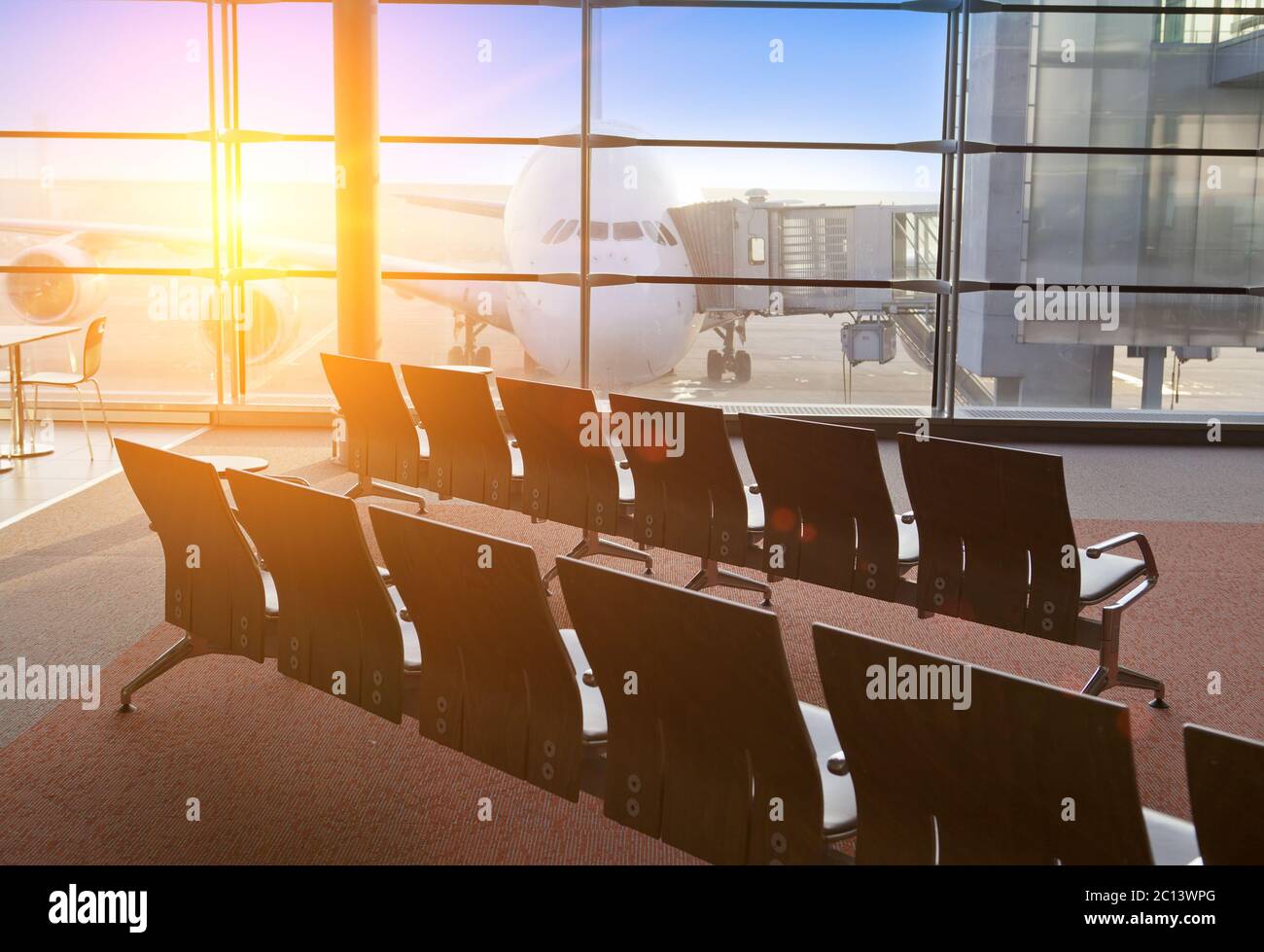 Leere Sessel im Saal der Erwartung des Flughafen und Flugzeug hinter Fenster Stockfoto