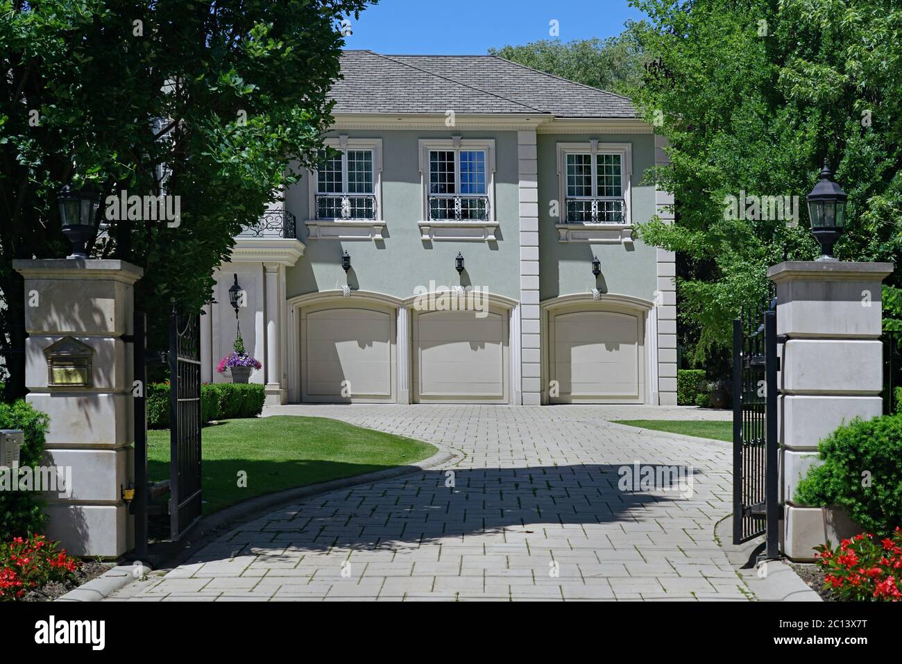 Toronto, Kanada - 12. Juni 2020: Die Forest Hill Gegend von Toronto hat große Häuser mit Landschaftsgärten, wie dieser eingezäunte Eingang zu einem drei Auto Stockfoto