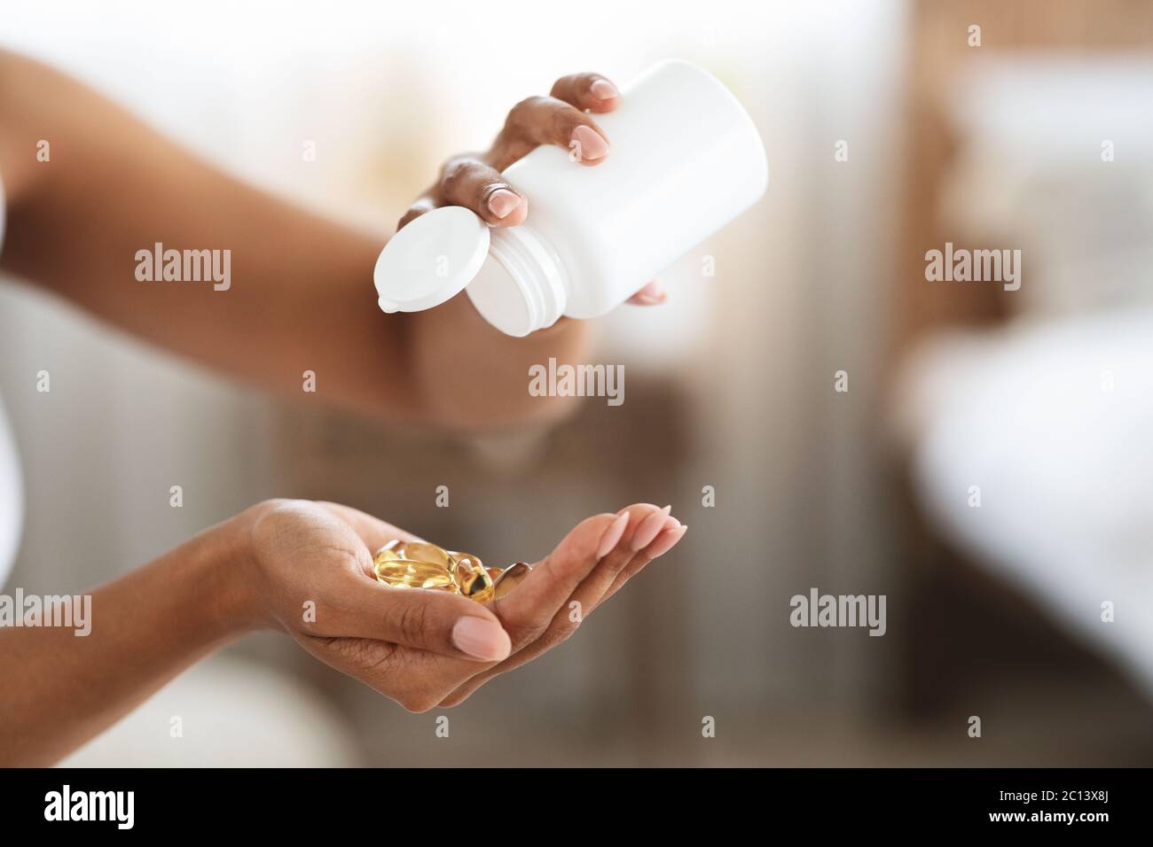 Unkenntlich Schwarz Weibliche Ausgießen Vitamin Nahrungsergänzungsmittel Kapseln Aus Der Flasche Stockfoto