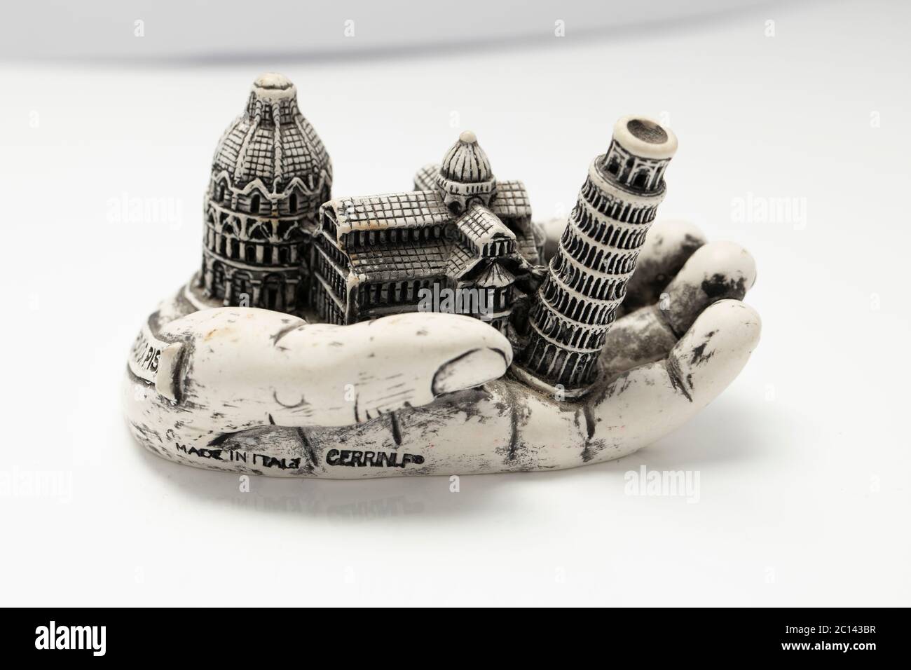 Interessanter Kuriosum, der einen Hand haltenden schiefen Turm aus Piza und die Kathedrale daneben zeigt, feiner Putz von paris verschenken Stockfoto