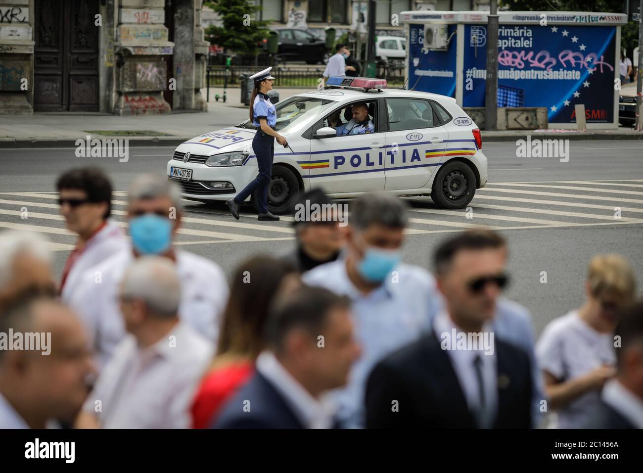 Bukarest, Rumänien - 13. Juni 2020: Rumänische Polizistin in der Nähe eines Polizeiwagens in der Innenstadt von Bukarest. Stockfoto