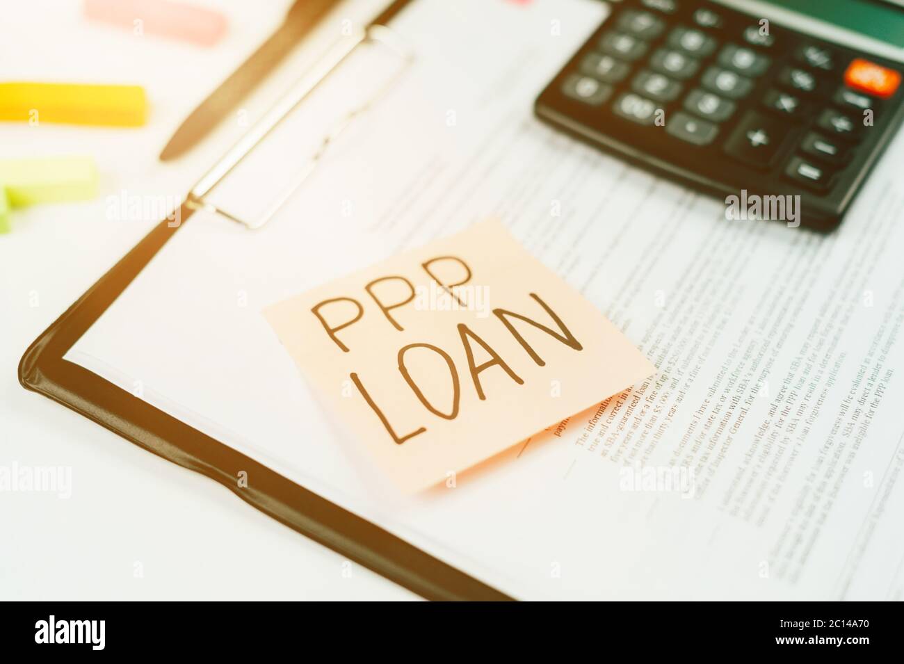 Aufkleber mit dem Text PPP-DARLEHEN auf dem Tablet für Papiere, Formulare zum Ausfüllen eines Kreditantrags. Stockfoto
