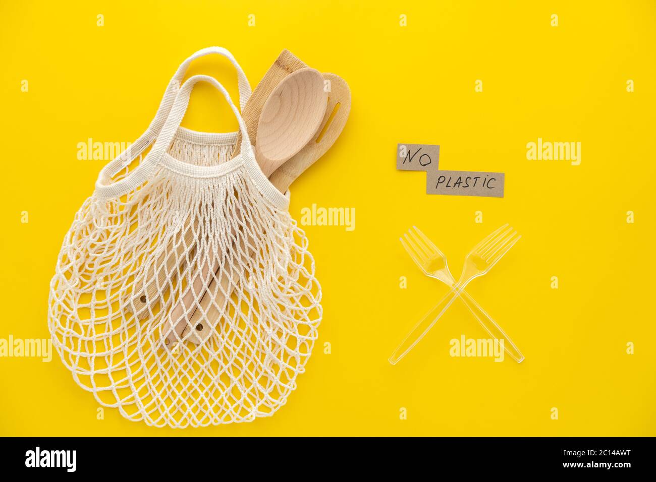 Kunststoff frei und Null Abfall Lifestyle Eco Store Konzept. Draufsicht, flach auf grünem Hintergrund von Netzbeutel und Löffel gelegt. Stockfoto