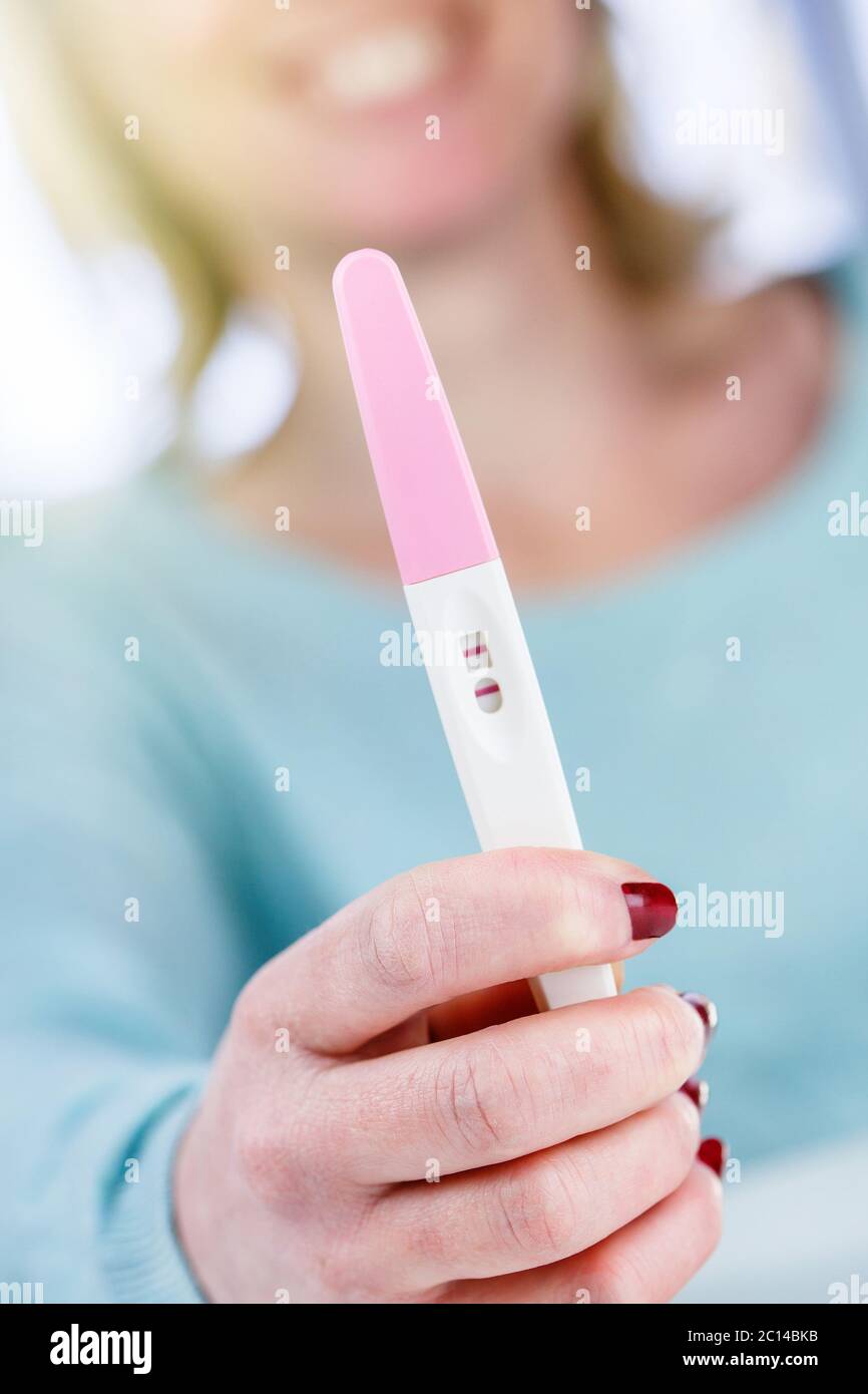 Schwangerschaftstest positiv lächelnde Frau Stockfoto