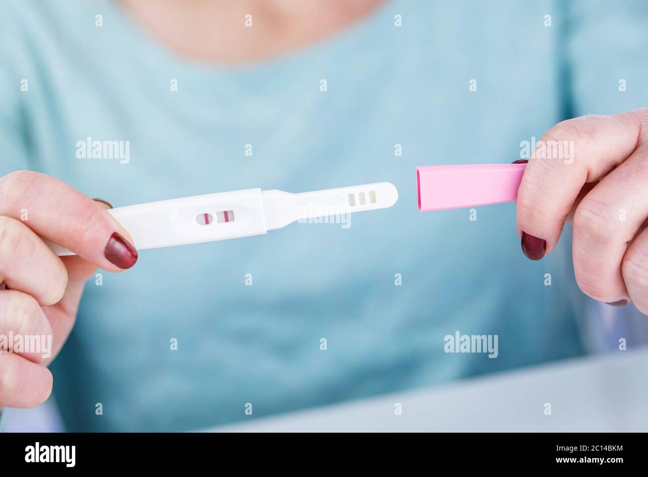 Frau mit einem Schwangerschaftstest Schwangerschaftstest positives Ergebnis in ihren Händen Stockfoto