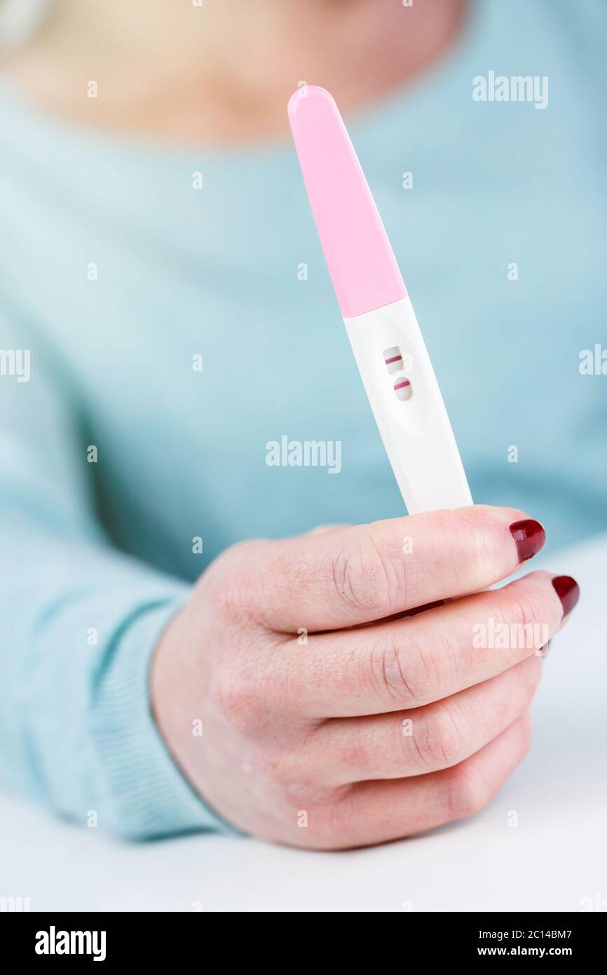Frau mit einem Schwangerschaftstest Schwangerschaftstest positives Ergebnis in ihren Händen Stockfoto