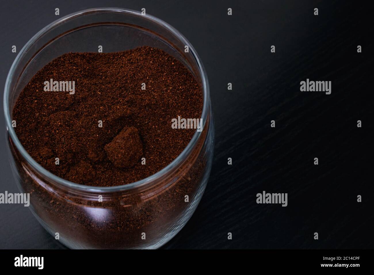 Gemahlener Kaffee in einem Glas auf dem schwarzen Holztisch, Platz kopieren Stockfoto