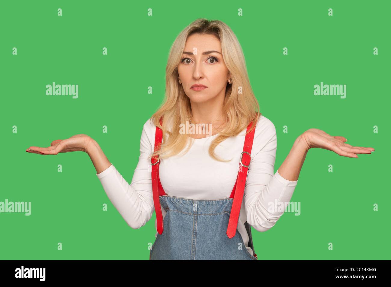 Ich bin verwirrt, weiß nicht! Porträt von ahnungslos verwirrt unsicher Erwachsenen blonde Frau in Denim Overalls stehend verlegen durch Frage, Zweifel answe Stockfoto