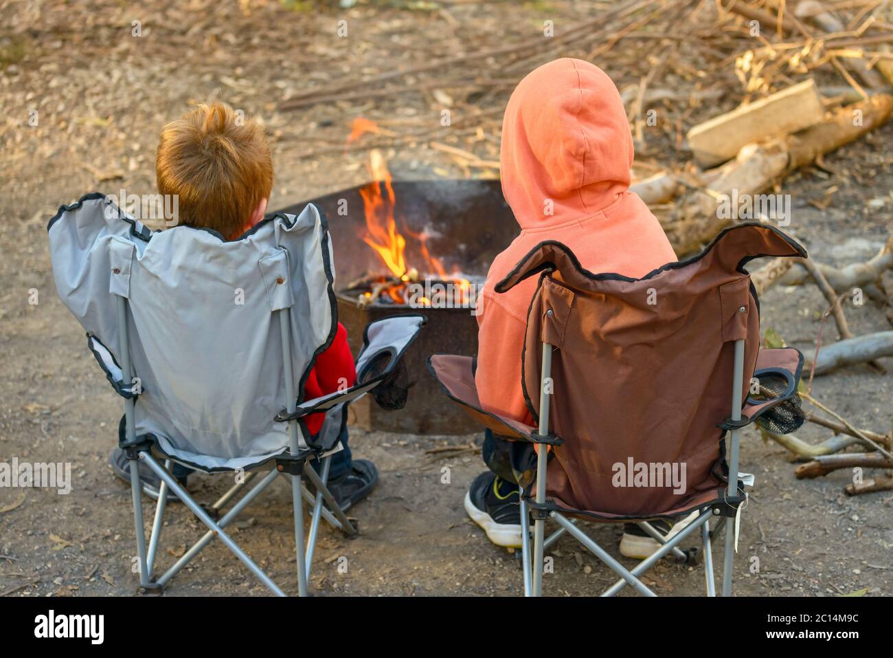 Kinder brennen Feuer auf Kuitpo Wald Campingplatz während der Winterschulferien, South Australia Stockfoto