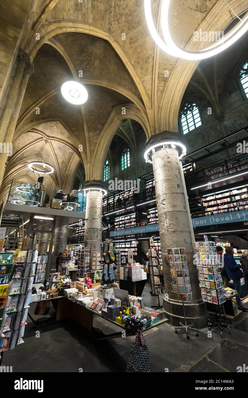 Innenansicht der Dominikanerkirche, die in eine Buchhandlung mit Restaurant, Kunden, Decken und Säulen der Kirche in Maastricht, Niederlande, umgewandelt wurde Stockfoto