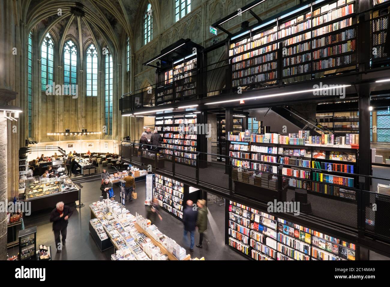 Innenansicht der Dominikanerkirche, die in eine Buchhandlung mit Restaurant, Kunden, Decken und Säulen der Kirche in Maastricht, Niederlande, umgewandelt wurde Stockfoto