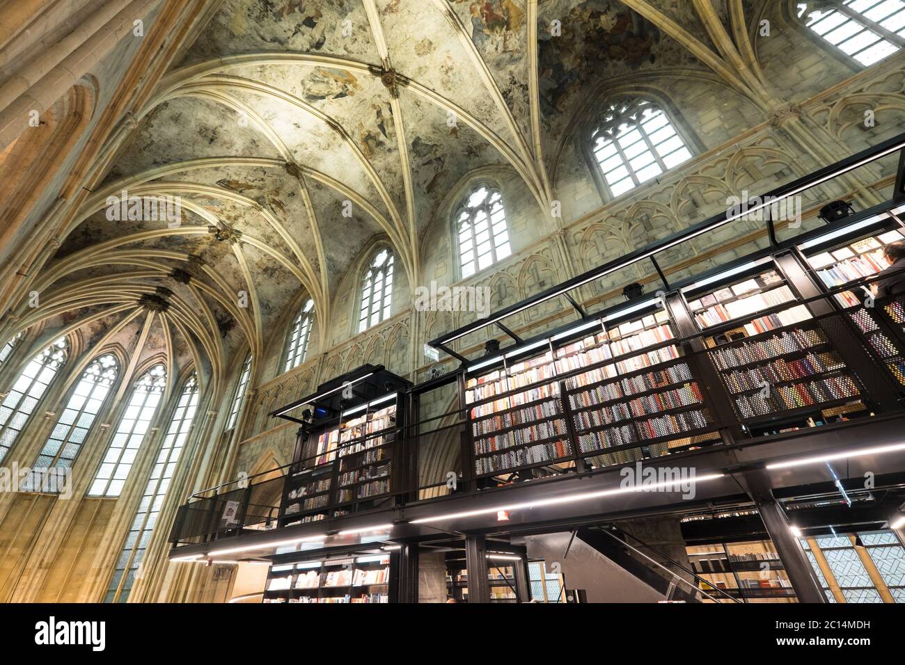 Innenansicht der Dominikanerkirche, die in eine Buchhandlung mit Restaurant, Kunden, Decken und Säulen der Kirche in Maastricht, Niederlande, umgewandelt wurde Stockfoto