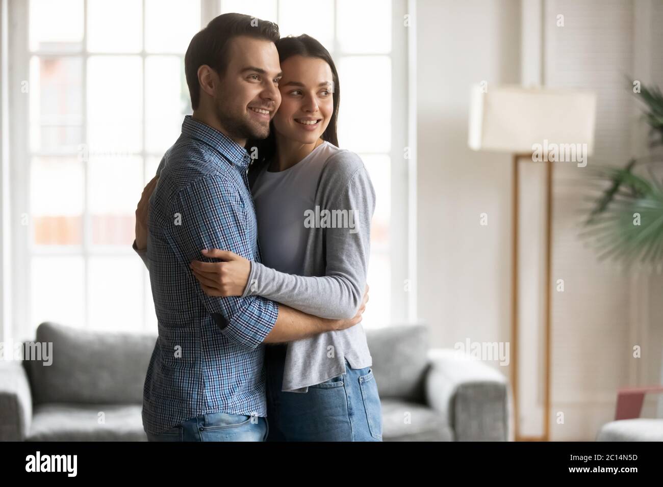 Glücklich verträumt Frau und Mann umarmt, Blick zur Seite Stockfoto