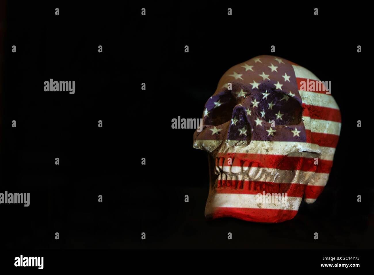 Isolierter weißer Schädel mit der amerikanischen Flagge der Vereinigten Staaten von Amerika, die darüber projiziert wird. Schlichter schwarzer Hintergrund. Covid-19 Corona-Virus oder Pistole Kontrolle Stockfoto