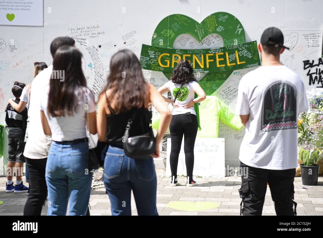 Menschen in der Grenfell Memorial Community Mosaik am Fuße des Tower Blocks in London zum dritten Jahrestag des Grenfell Tower Feuers, der am 14 2017. Juni 72 Menschenleben forderte. Stockfoto