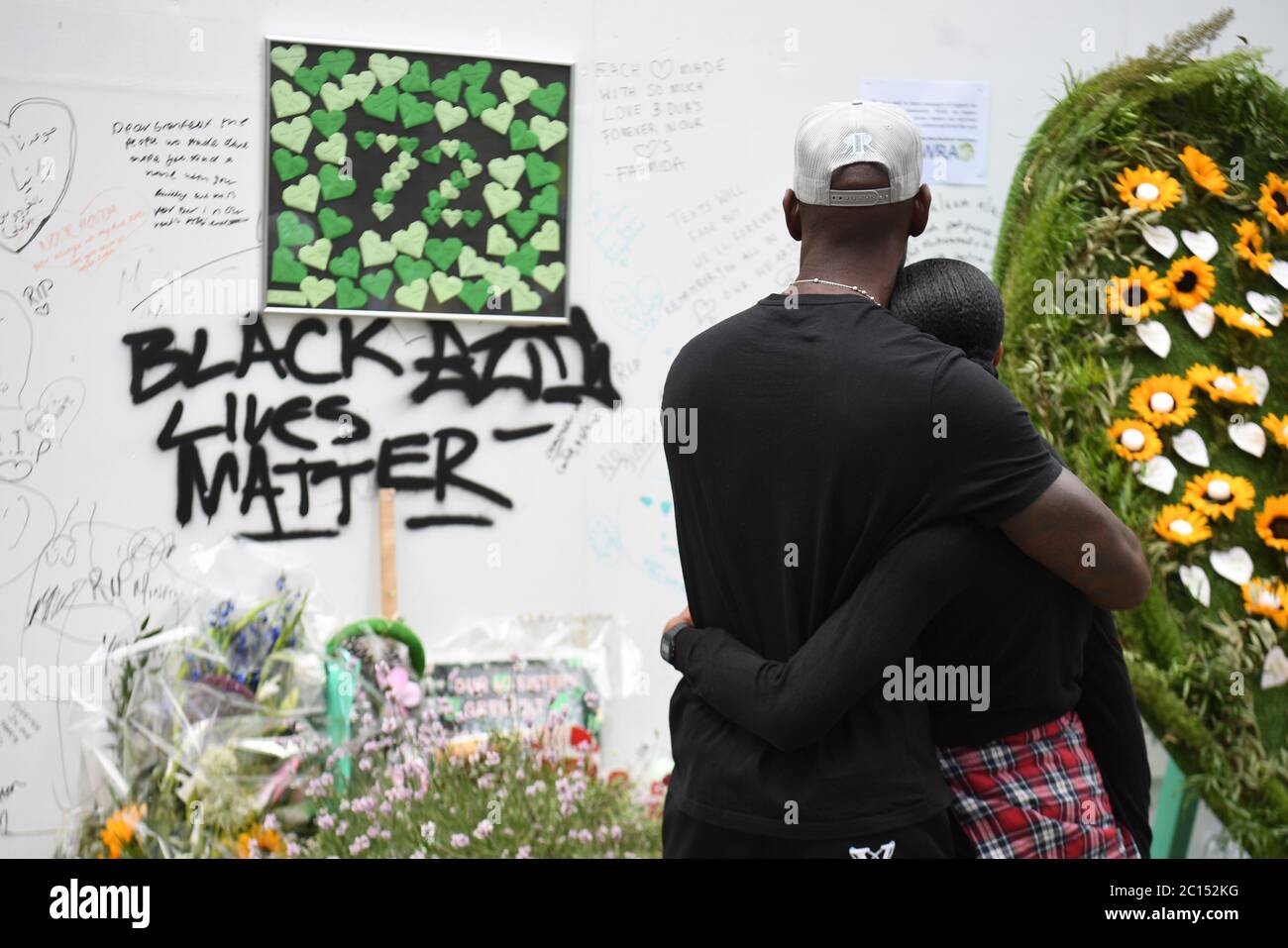 Menschen in der Grenfell Memorial Community Mosaik am Fuße des Tower Blocks in London zum dritten Jahrestag des Grenfell Tower Feuers, der am 14 2017. Juni 72 Menschenleben forderte. Stockfoto