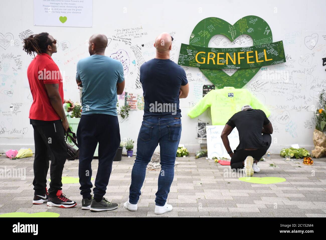 Menschen in der Grenfell Memorial Community Mosaik am Fuße des Tower Blocks in London zum dritten Jahrestag des Grenfell Tower Feuers, der am 14 2017. Juni 72 Menschenleben forderte. Stockfoto