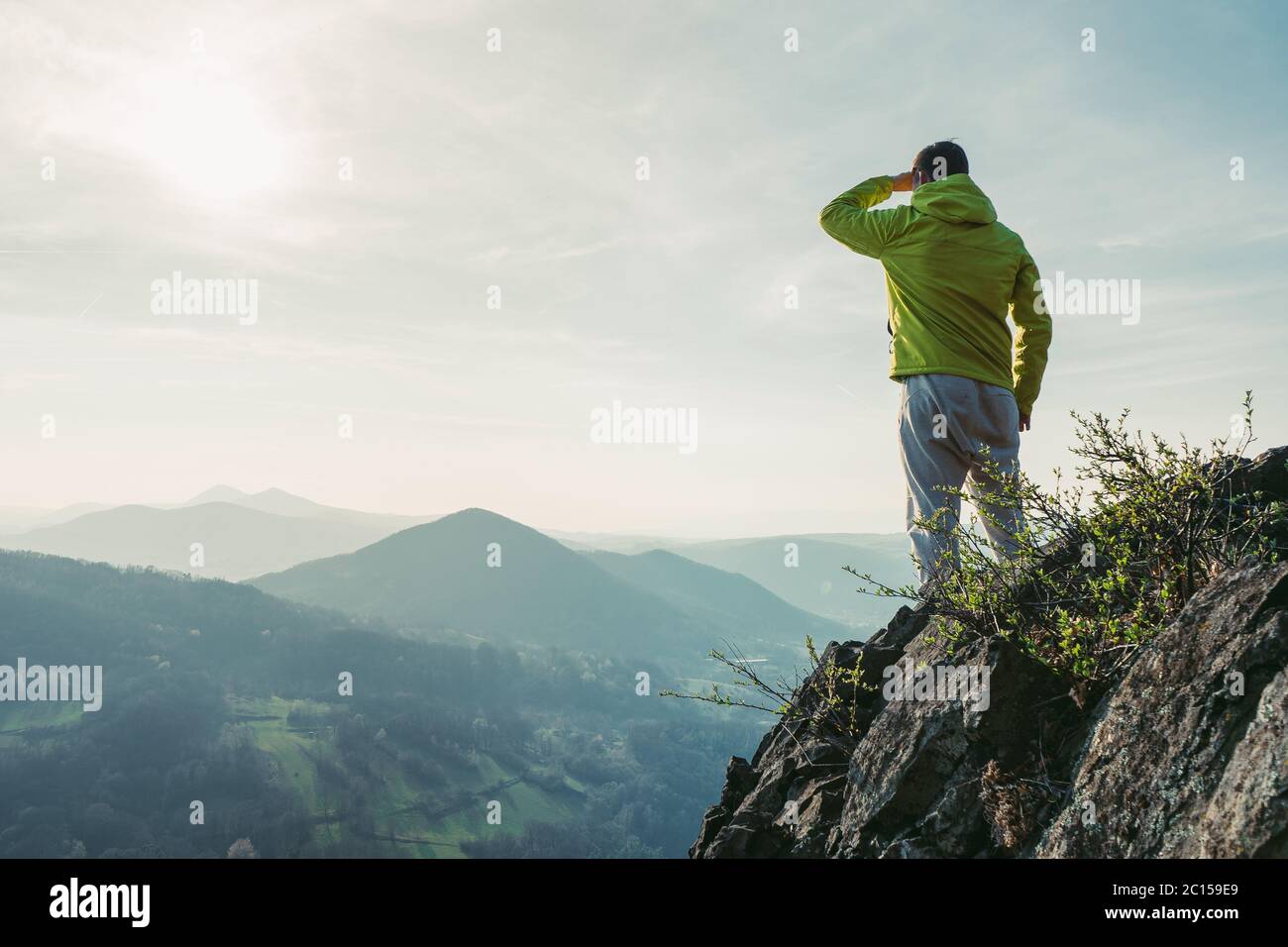Wanderer beobachten, Sonne am Horizont. Schöner Moment, das Wunder der Natur. Bunte Nebel im Tal. Menschen wandern. Stockfoto