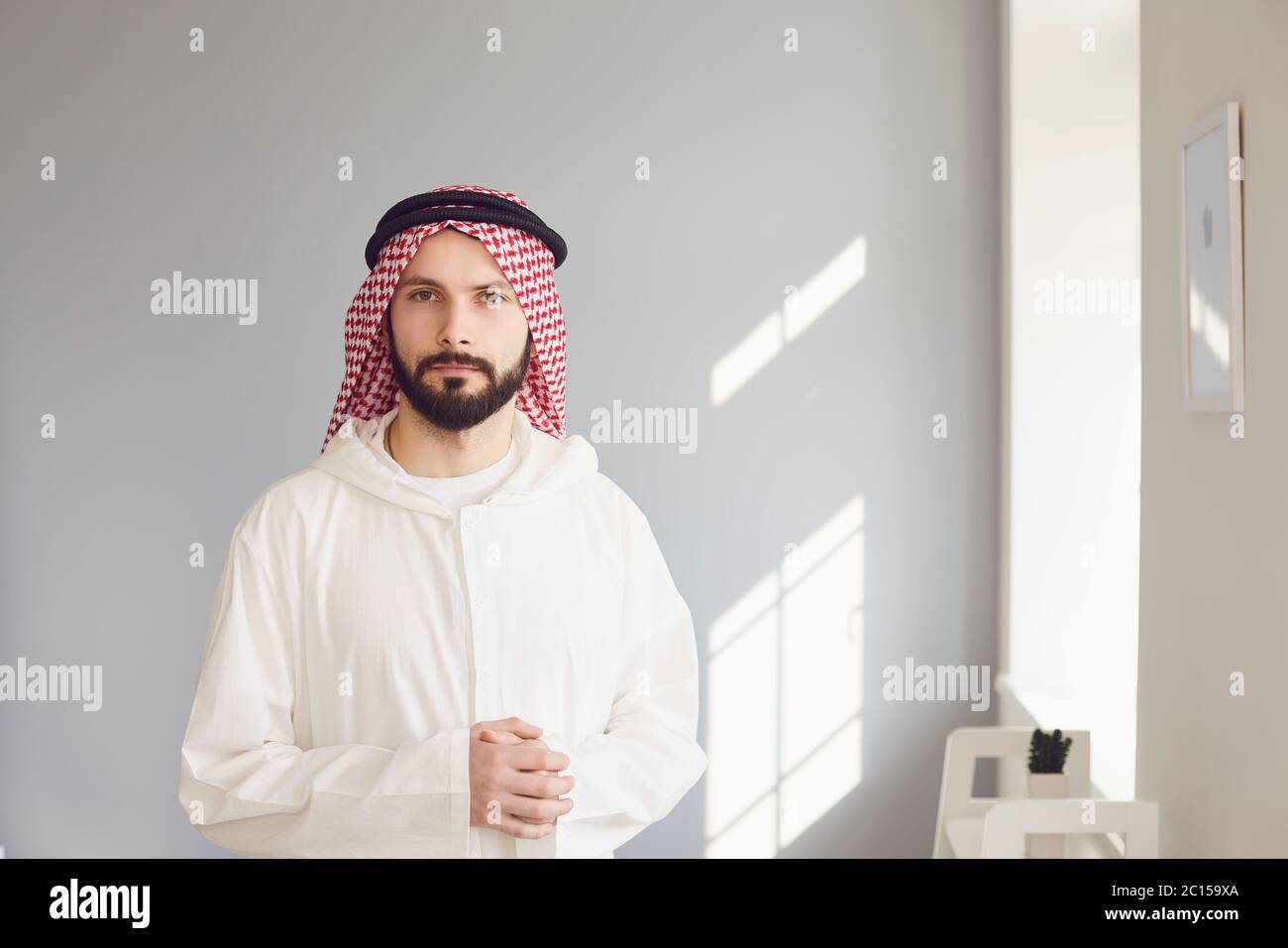 Arabischer männlicher Geschäftsmann lächelndes Porträt, das auf grauem Hintergrund steht Stockfoto