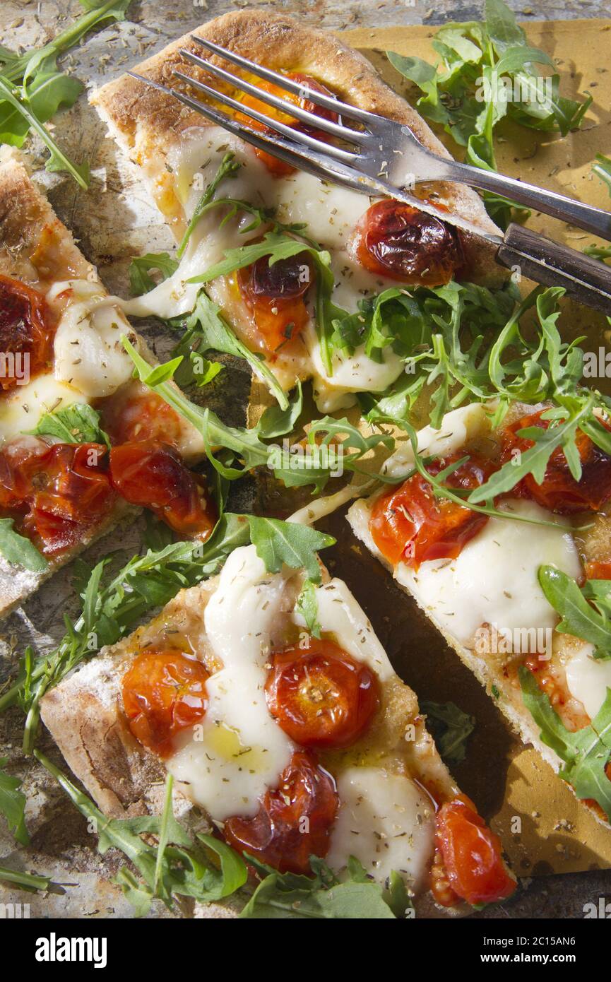 Pizza mit Tomaten und Rucola Stockfoto