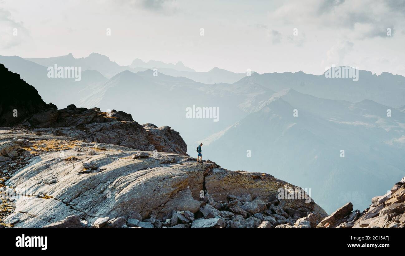 Mann auf gelungener Wanderung, Silhouette in den Bergen der Schweiz. Wanderer auf dem Gipfel des Berges mit Blick auf die schöne Landschaft. Schweizer Alpen, Europa Stockfoto