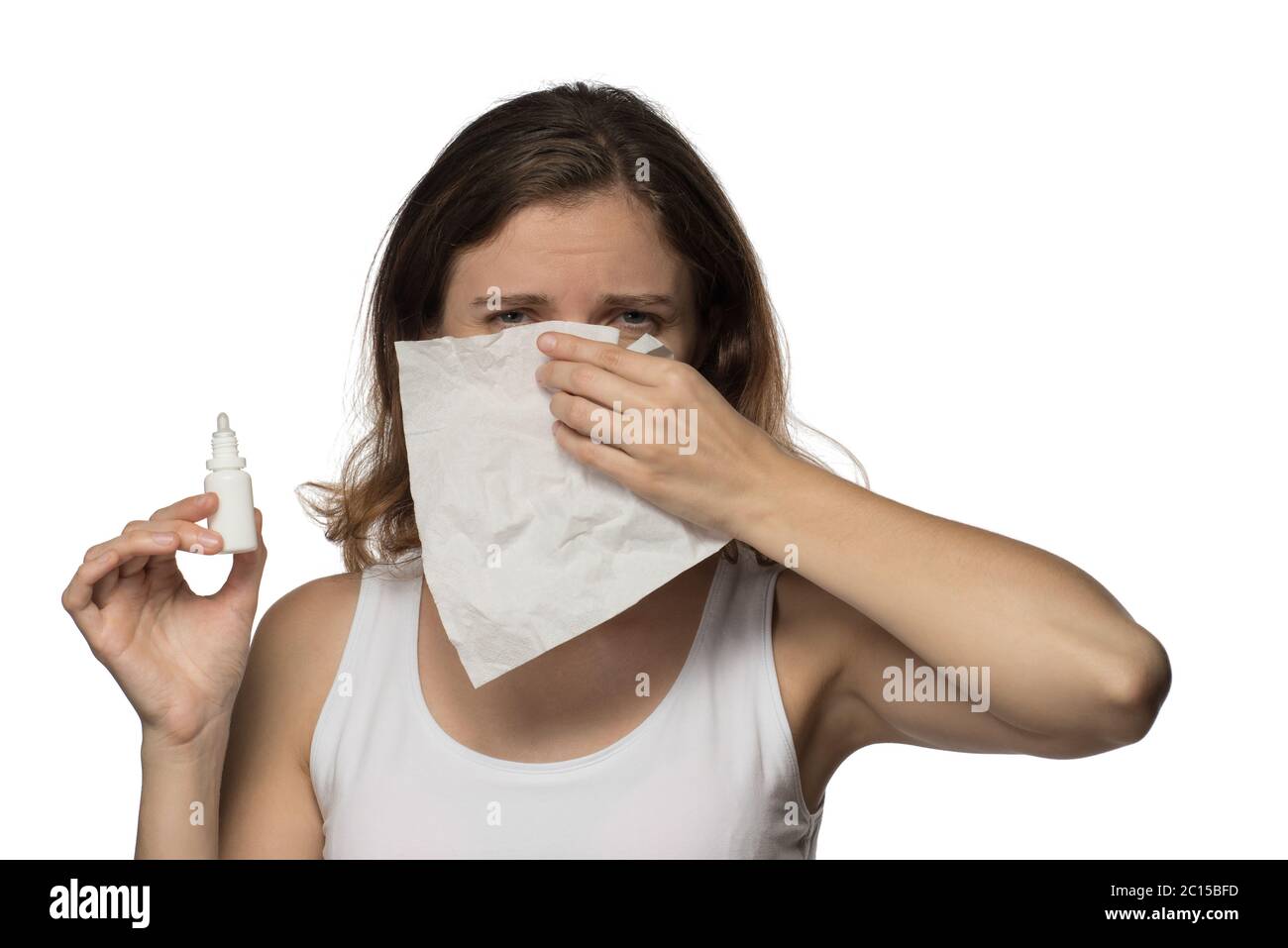 Eine schöne junge Brünette Frau wird krank mit einer kalten und laufenden Nase, niest und hustet in ein weißes Papier-Tuch Stockfoto