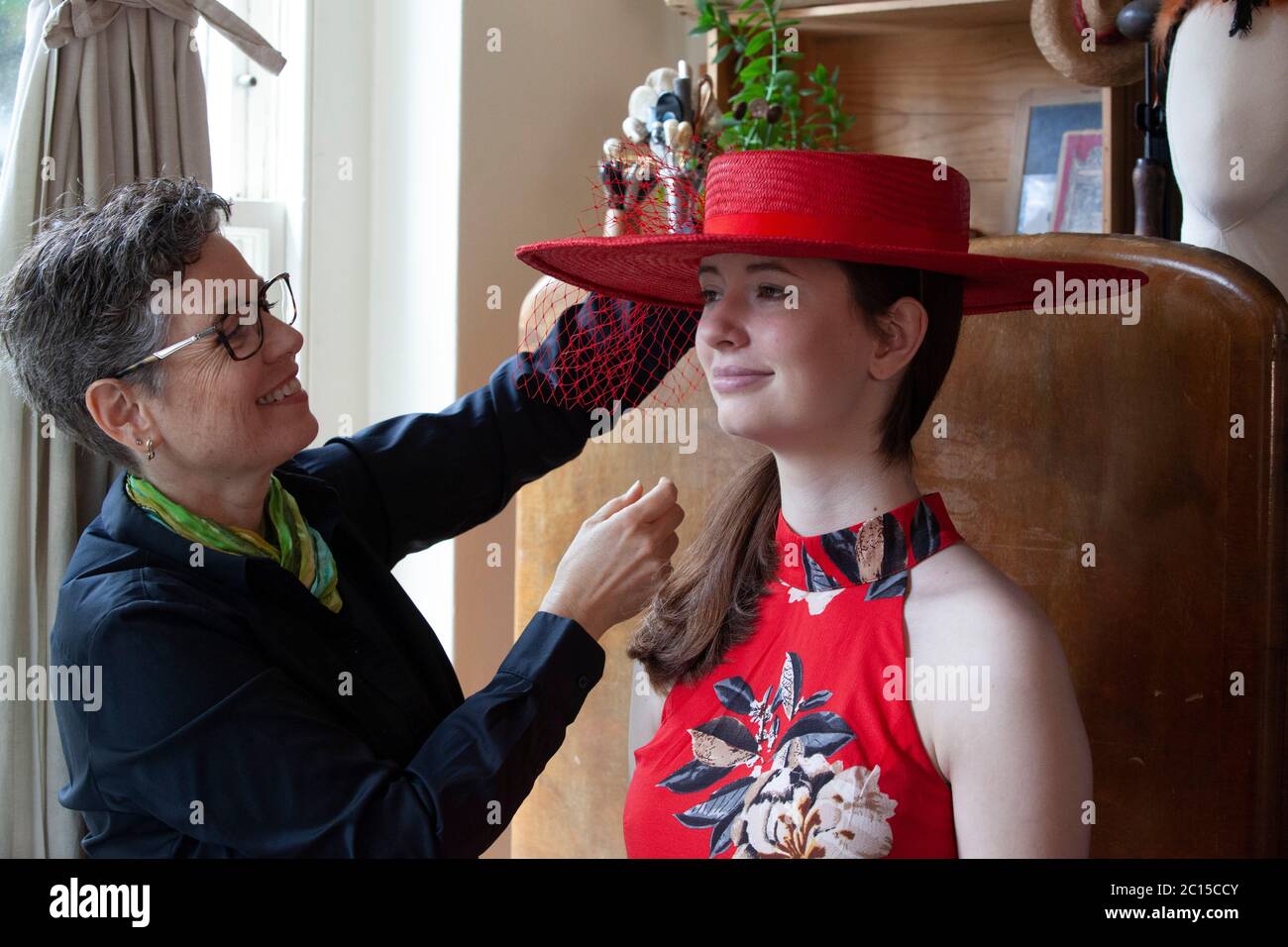 London, Großbritannien, 14. Juni 2020: Milliner Leanne Fredrick bereitet einen ihrer Hüte, von ihrer Tochter Emeline modelliert, für die Social Media-Spendenaktion "Royal Ascot at Home" vor, die vom 16. Bis 20. Juni läuft. Da das Pferderennen und die soziale Veranstaltung aufgrund von Maßnahmen zur sozialen Distanzierung durch Coronavirus abgesagt wurde, werden die Menschen ermutigt, Fotos ihrer Hüte und Outfits mit dem Haag zu posten #StyledWithThanks and make a donation to Ascot's Chosen Covid-19 Charities. Anna Watson/Alamy Live News. Stockfoto