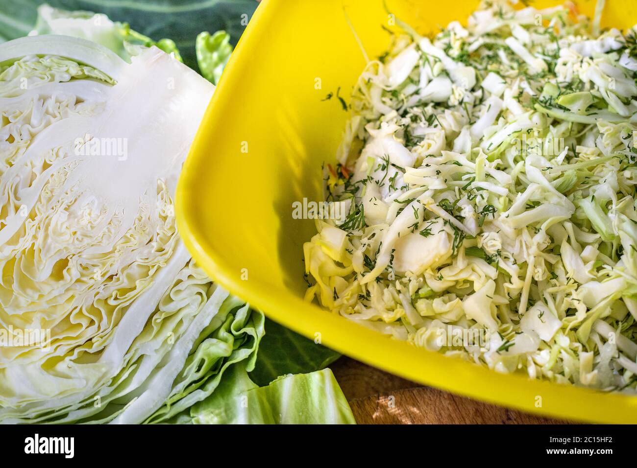 Kohl in Scheiben für Salat. Weißkohlblätter. Gemüse zum Abendessen. Rohe Leckereien. Ländliche Tischvorbereitung für das Abendessen. Stockfoto