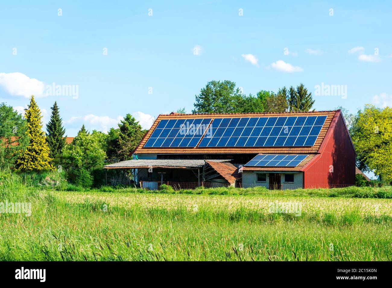 Grüner Energie mit Solarkollektoren auf dem Dach eines landwirtschaftlichen Gebäudes Stockfoto