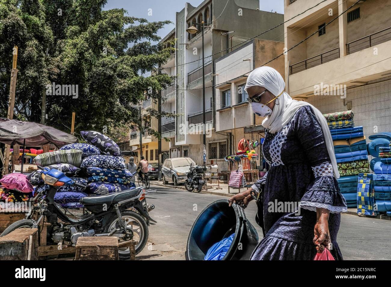 Dakar. Juni 2020. Eine Frau mit Gesichtsmaske geht am 13. Juni 2020 in Dakar, Senegal. Das senegalesische Ministerium für Gesundheit und soziale Aktion berichtete am Sonntag über 94 neue bestätigte Fälle von COVID-19, womit die Gesamtzahl der Infektionen im Senegal auf 5,090 Fälle angewachsen ist. Kredit: Eddy Peters/Xinhua/Alamy Live Nachrichten Stockfoto