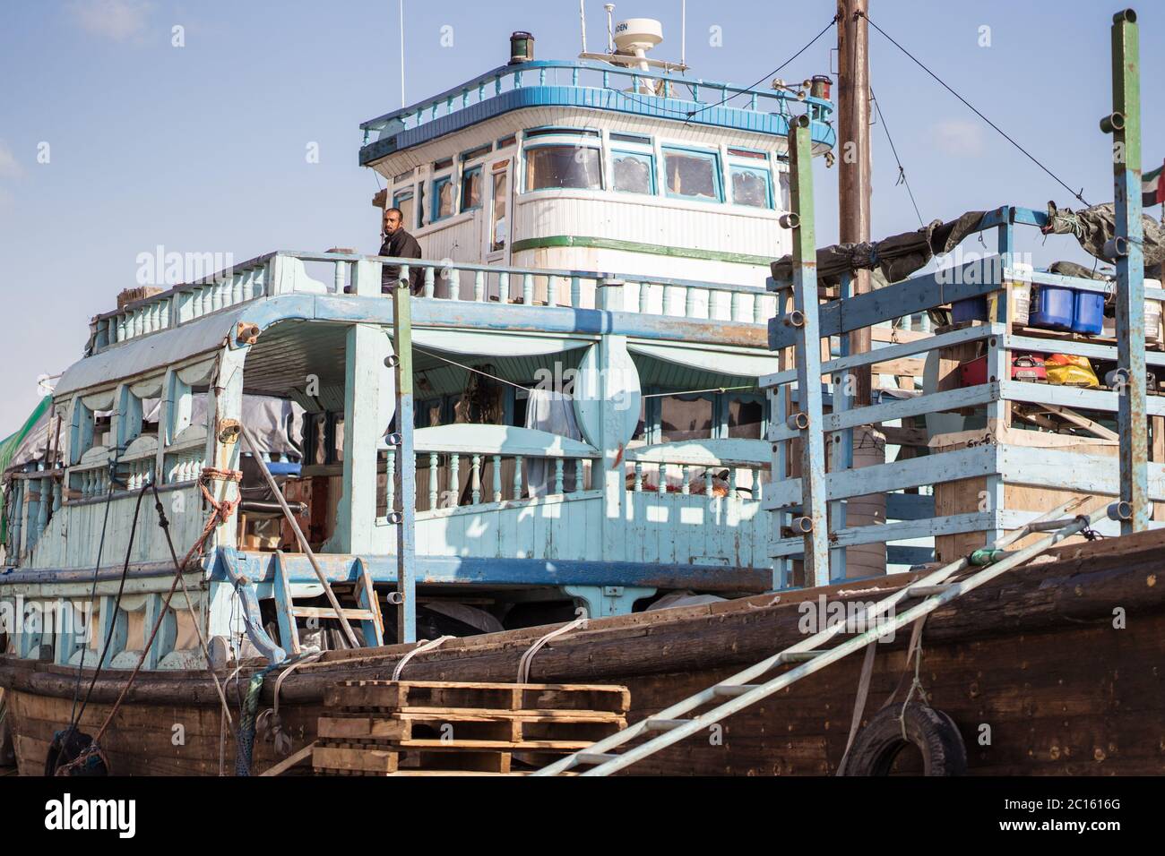 Dubai / Vereinigte Arabische Emirate - 1. Februar 2020: Wanderarbeiter arbeiten in traditionellen bunten Booten im Stadtzentrum von Dubai Hafen Stockfoto