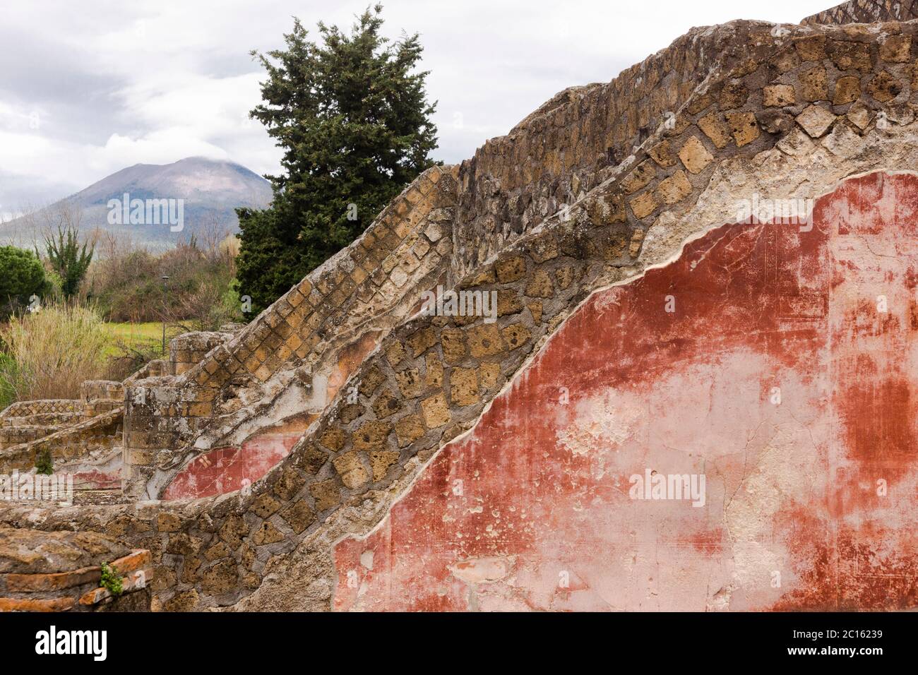 Blick über die teilweise mit farbigem Putz bedeckten Mauern zum Vesuv in der antiken Stadt Pompeji, Kampanien, Italien Stockfoto