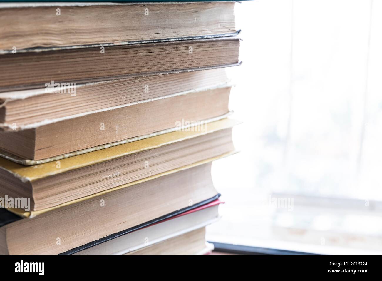 Ein Stapel alter Bücher, die auf einer Fensterbank liegen Stockfoto