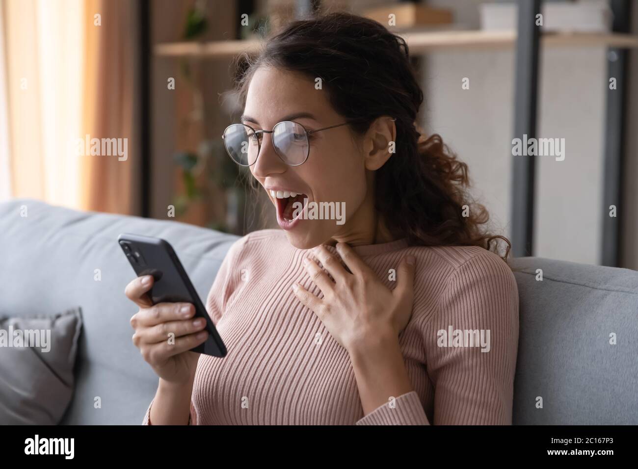 Aufgeregt Frau Lesen unerwartete gute Nachricht, Blick auf Telefonbildschirm Stockfoto