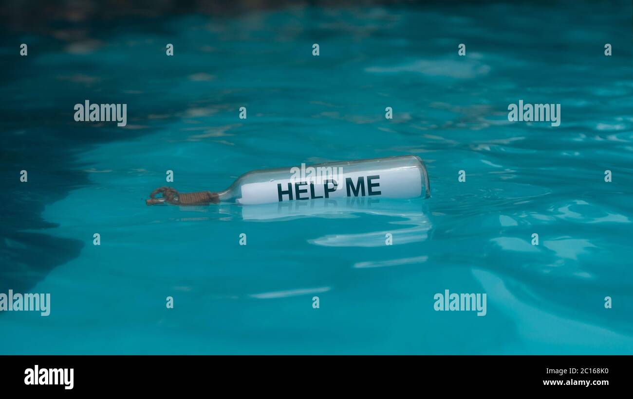 HILF MIR Nachricht geschrieben auf einem weißen Papier in der Glasflasche schwimmt in blauem Wasser in der Mitte des Meeres Stockfoto