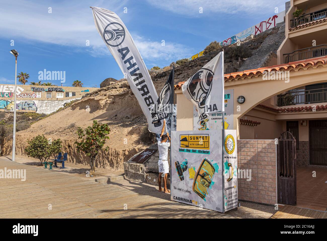 Die Anwohner haben den Strand für sich, da das Wetter für den Sommer hochgeht. Kite Surf Schule stellt Werbebanner, Fahnen. Phase 3 De-escala Stockfoto