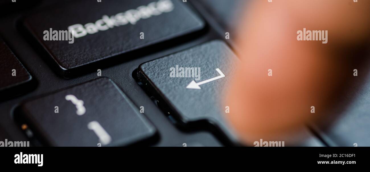 Enter-Taste mit einem Finger auf der Tastatur gedrückt Stockfoto