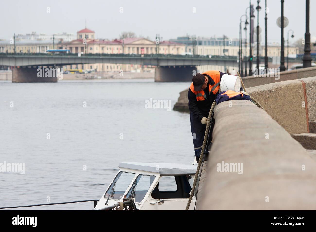 Der Maurer repariert die Nahten zwischen den Granitplatten am Ufer des Flusses Fontanka in St. Petersburg Stockfoto
