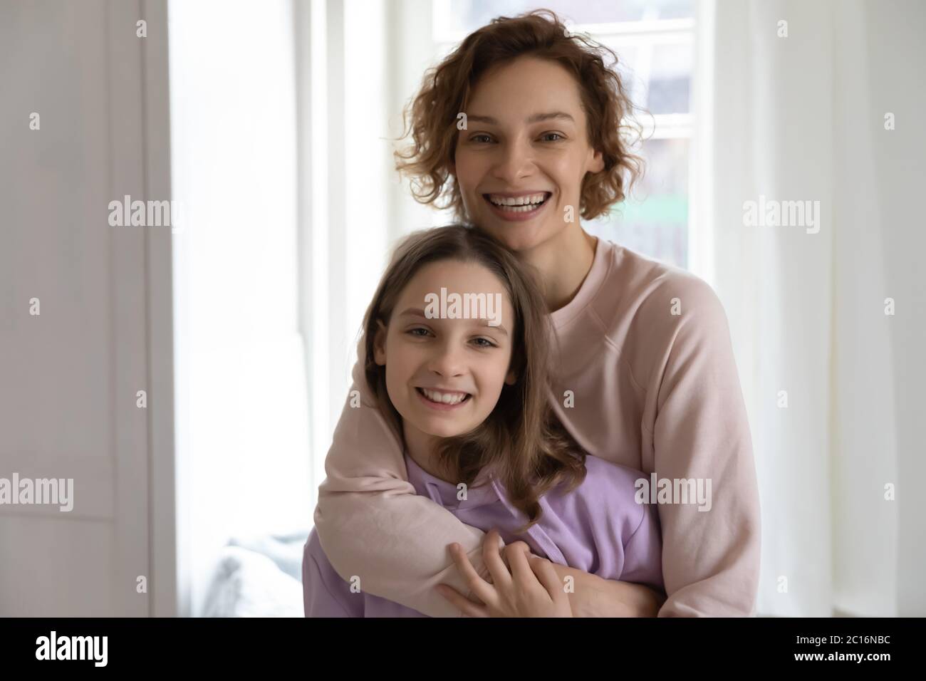 Portrait von glücklich Mutter und teen Tochter Umarmung Stockfoto