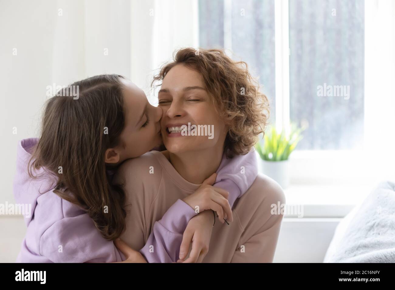 Dankbar teen Tochter küssen glücklich junge Mutter Stockfoto