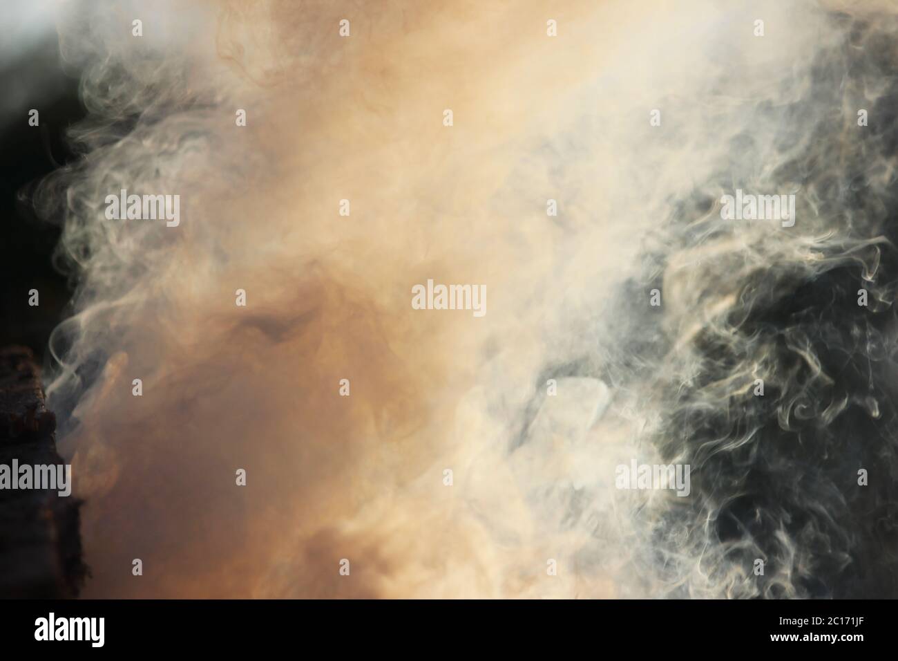 Weißer Rauch aus dem Feuer, wo feuchte Bretter und Sägemehl liegen. Stockfoto