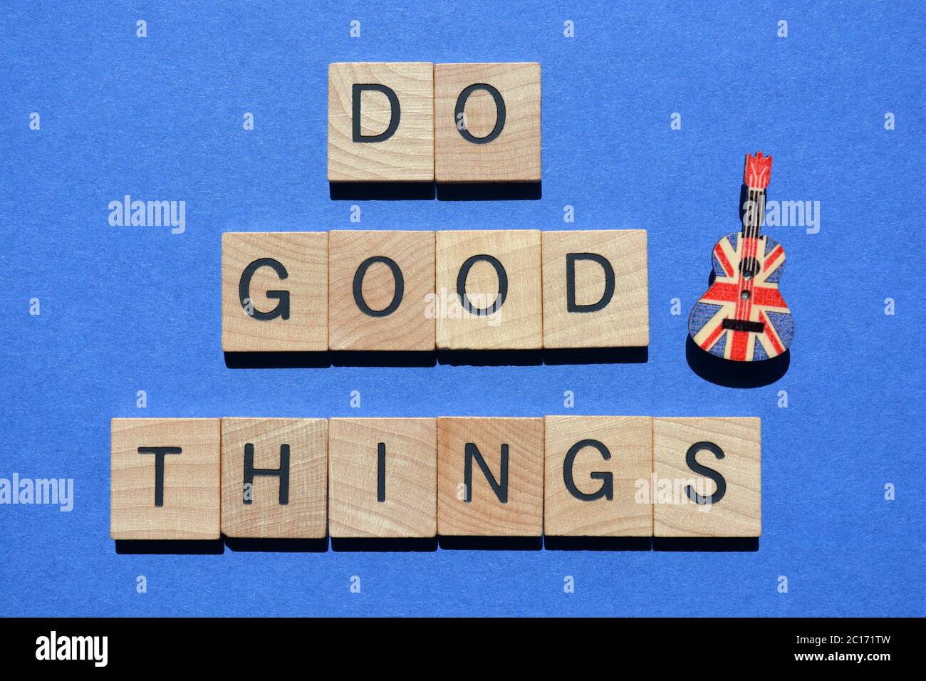 Tun gute Dinge, Wörter in 3D-Holz-Alphabet Buchstaben mit einem Ukulele-Stift, isoliert auf blauem Hintergrund Stockfoto