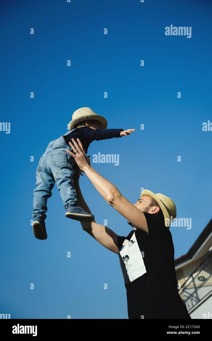 Zu Hause bleiben: Ein Vater und sein kleiner Sohn spielen zusammen im Hinterhof. Stockfoto