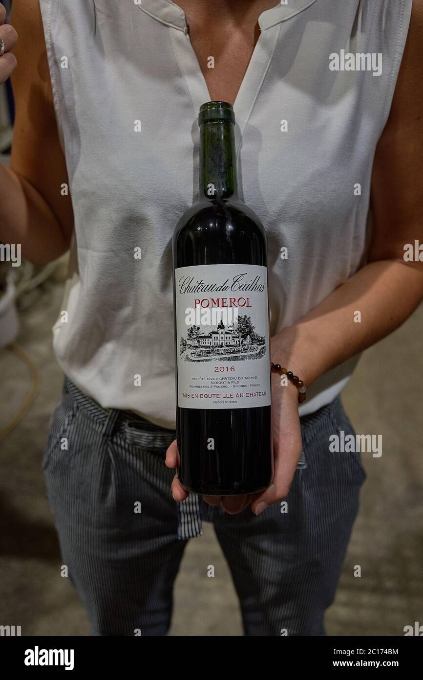 Führer in einer weißen Bluse hält eine Flasche Château du Tailhas Pomerol Rotwein, Bordeaux, Frankreich Stockfoto