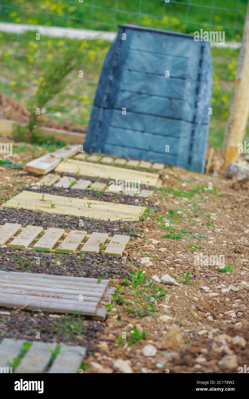Holzsteg aus Plattenholz mit schwarzem Kunststoffbehälter im Stadtgarten Stockfoto
