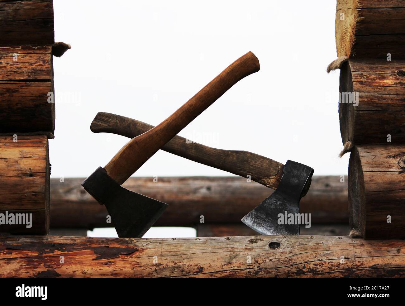 Zwei Achsen auf der Bau eines Holzhauses sind bereit für die Arbeit Stockfoto