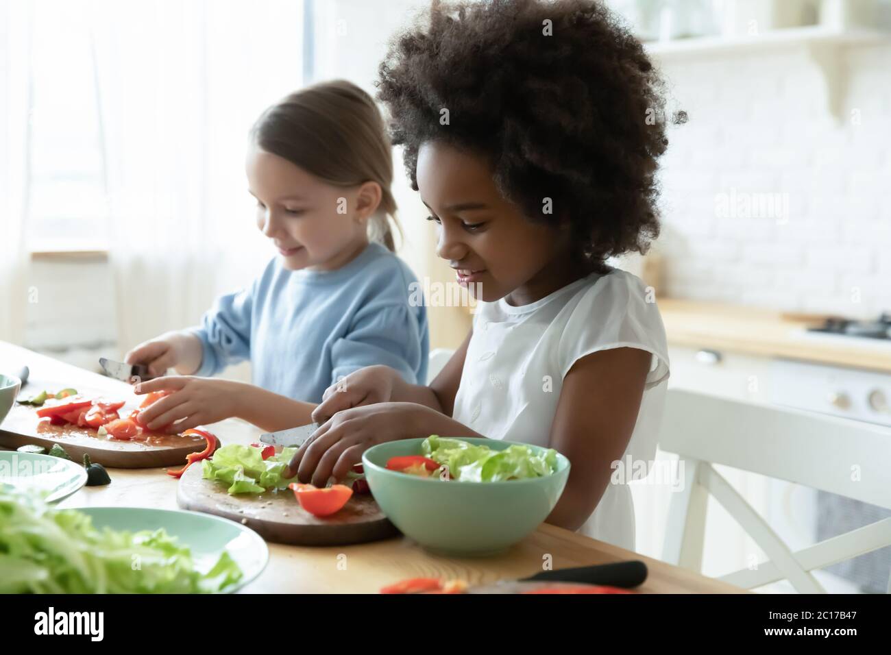 Multirassische kleine Mädchen besten Freunde Kochen zusammen in der Küche Stockfoto